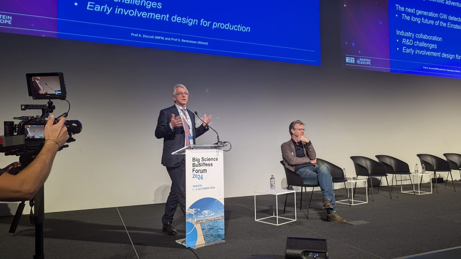 The photo shows a man presenting on stage during the BSBF meeting in Trieste 2024.