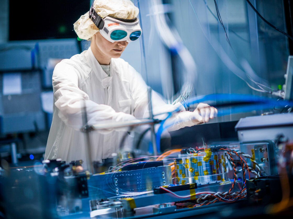 An image shows an Albert Einstein Institute postdoc Nina Bode working on an ET-HF high-power laser prototype.