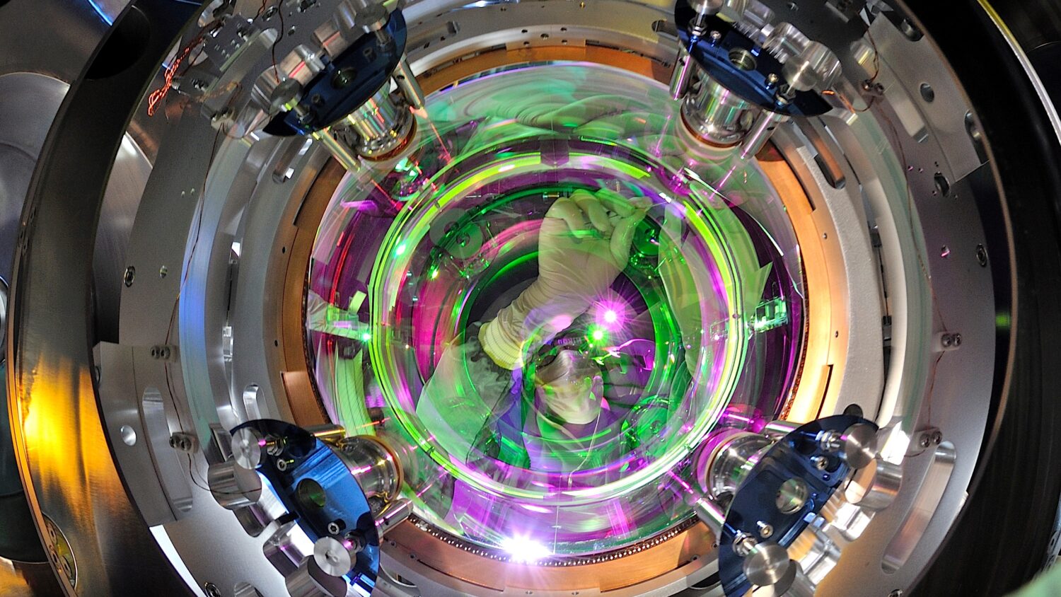 An image shows a researcher working on one of the mirrors of the Virgo gravitational wave detector. Credits: Maurizio Perceiballi/EGO-Virgo
