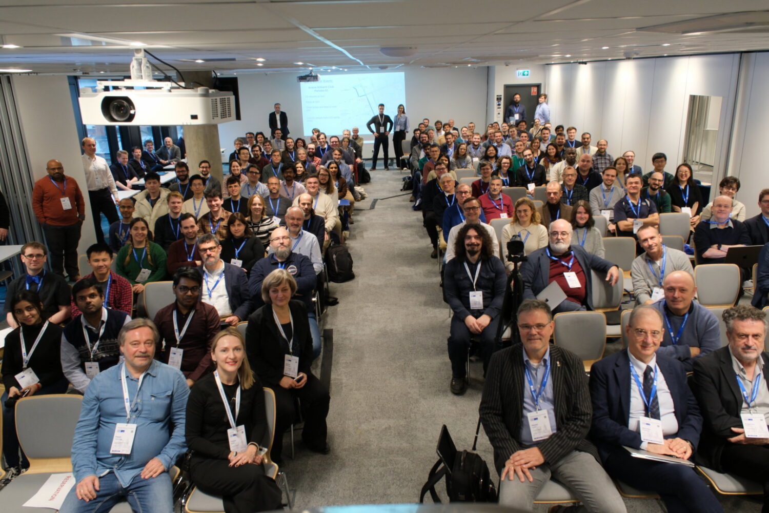 An image of people gathered for a lecture and posing for a photo during the ET annual meeting in Warsaw 2024.