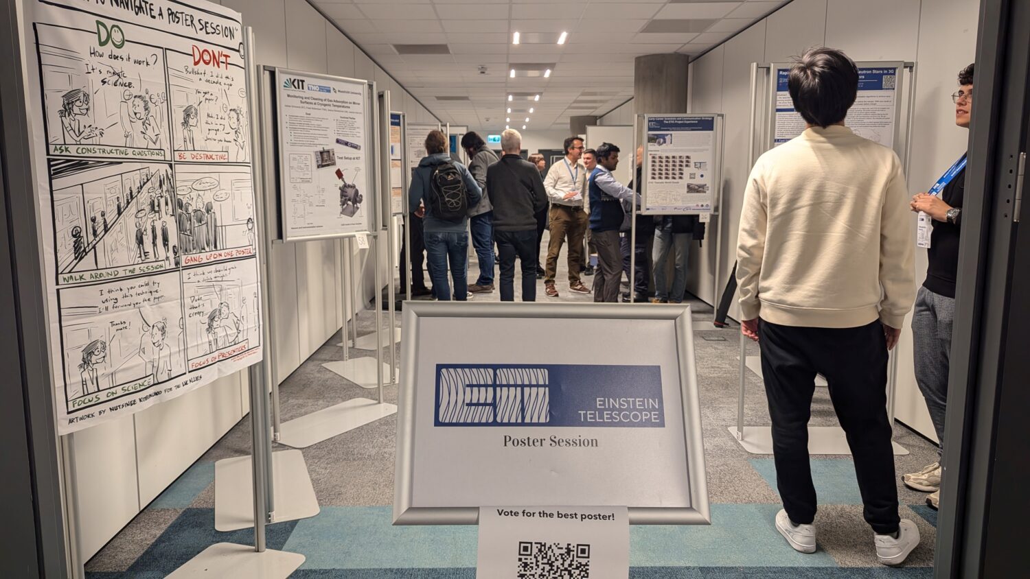 The photo shows a group of people chatting and watching the posters during the poster session for the ET annual meeting in Warsaw 2024.