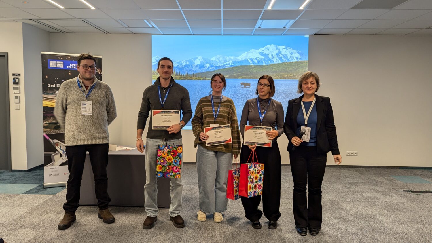 The photo shows a group of five people posing for a picture during the ET annual meeting in Warsaw 2024 - three of them are the winners of the best poster for the poster session.